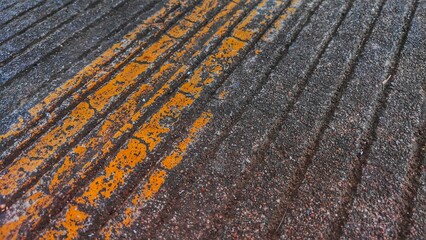 Worn Asphalt Road Texture with Faded Yellow Line Background, can be used for themes related to travel, construction, city life, street surfaces, aging infrastructure, or industrial design. © Rahims
