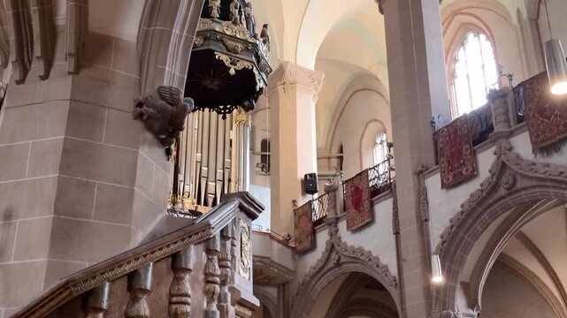 Smooth pan up highlighting craftsmanship and architectural detail of the pulpit within the Black Church, Transylvania.