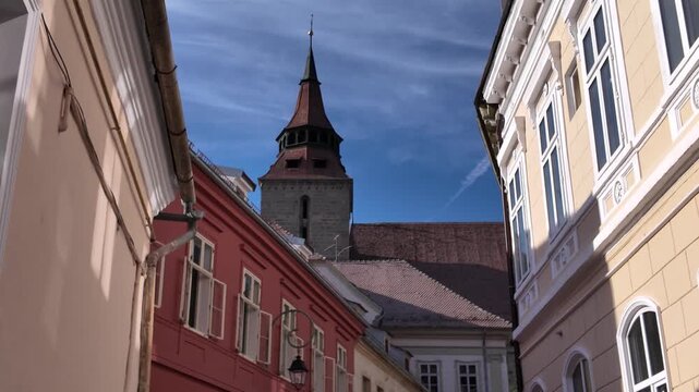 Urban view capturing the Black Church tucked among city buildings in Brașov, Romania.