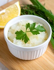 Lemon caviar pearls in a white ramekin on a wooden board, garnished with fresh parsley and dill