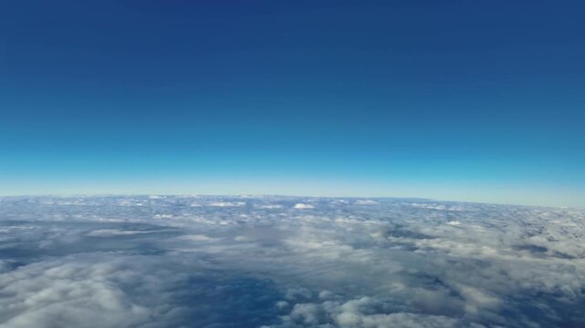 Stratiospheric POV flying at supersonic speed over an endless layer of clouds under a blue sky.4K Hyperlapse x5 shot. Cruising Level 450 with a Curved Horizon View.