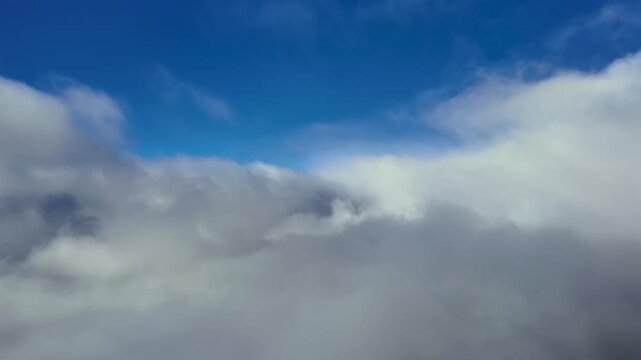 Immersive pilots view POV captured from a jet cokpit in a flight through an endless layer of stratocumulus clouds under a blue sky. Hyperlapse x4
