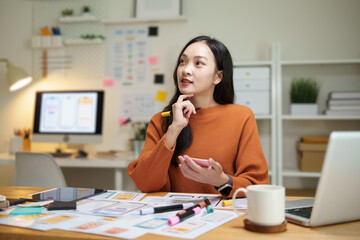 UX UI designer sketching mobile app wireframes while testing interface ideas on tablet. Concept of user centered design and digital product development.