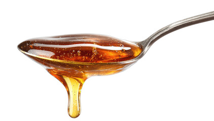 Spoon of golden viscous liquid dripping against a black background