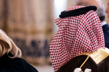 Shallow depth of field details with a man in an audience wearing a muslim Ghutra,Shemagh,Keffiyeh, a square cotton scarf held by a black cord called an Agal