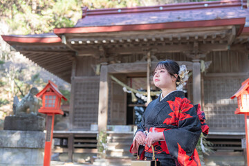 神社でお参りする着物姿の女性
