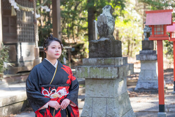 神社でお参りする着物姿の女性
