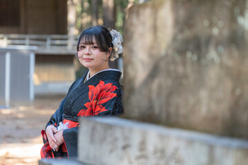 神社でお参りする着物姿の女性