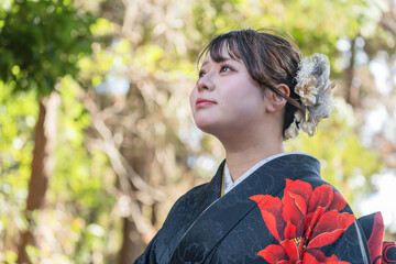 神社でお参りする着物姿の女性