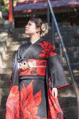 神社でお参りする着物姿の女性