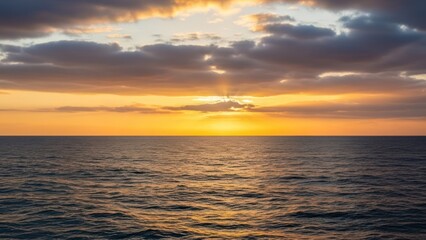 Fototapeta premium Golden sunset over ocean, with radiant sun rays bursting through clouds