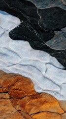 Fototapeta premium Layered rock textures with wavy bands of black, pale blue-gray, and orange-brown earth tones. With fine bands!