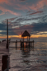Fototapeta premium A stunning and colorful sunrise on a wooden pier on the beach in Cancun, Mexico