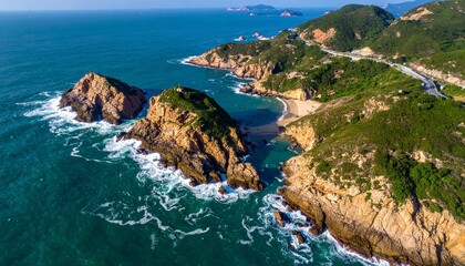 Coastal landscape with rugged cliffs and rocky outcrops, waves crashing into white surf, winding road along green hills, vibrant contrast between deep blue ocean and lush land under clear sky.