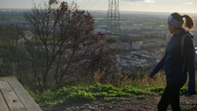 A woman reaches the top of the mountain on a beautiful day.