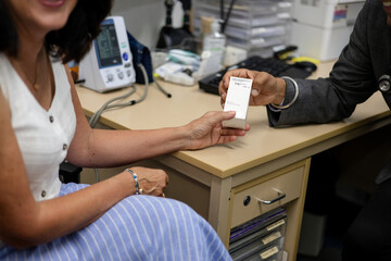 Doctor handing prescription medicine to female patient