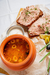 Enjoy a warm bowl of soup paired with hearty bread and a creamy spread, perfect for sharing