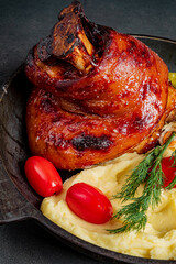 Juicy roasted meat glistens with flavor, paired with velvety mashed potatoes and vibrant tomatoes