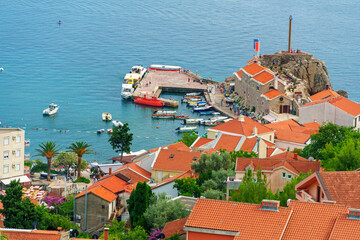 Harbor and pier with boats in the coastal town of Petrovac Montenegro seen from above.