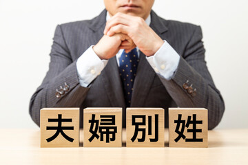 Obraz premium 「夫婦別姓」と書かれたブロックとビジネスマン