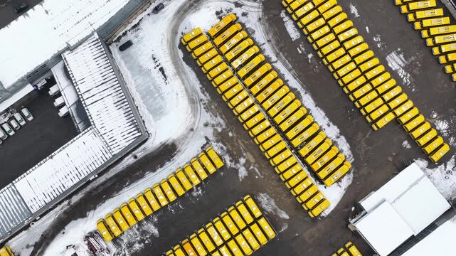 Almaty, Kazakhstan - 12.18.2025 : Large parking lot for yellow school buses. The view from the drone. Winter time, snowfall.