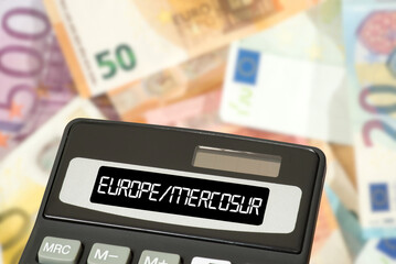 Euro banknotes and a calculator symbolize the costs and profit of the free trade agreement between...