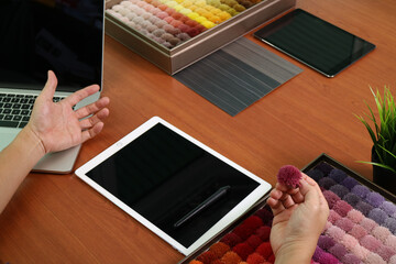 Interior designer selecting fabric color samples on modern workspace desk