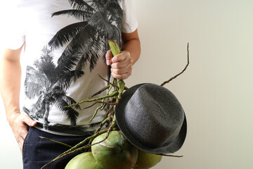 Man Holding Fresh Coconuts with Black Hat