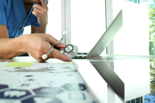 Doctor working with laptop and stethoscope in modern clinic - Powered by Adobe