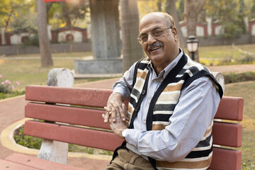 Fototapeta premium Portrait of a indian old senior man spending time at park after retirement 
