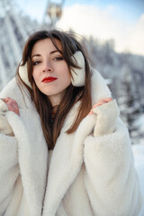 Girl in a white fur coat, winter portrait with snowy background, cozy and stylish cold season fashion look.