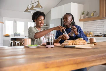 Selbstklebende Fototapeten Zu Kochen African american couple passing pepper grinder and preparing breakfast in kitchen  © wavebreak3