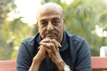 Portrait of a Indian sad, depression, thinking, Upset lonely homeless senior man in garden sitting...