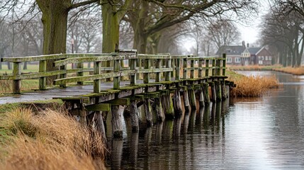 Old Wooden Bridge Over a Calm Canal in a Rural Landscape