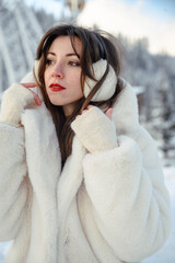 Girl in a white fur coat, winter portrait with snowy background, cozy and stylish cold season fashion look.