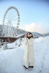 Girl in a white fur coat, winter portrait with snowy background, cozy and stylish cold season fashion look.