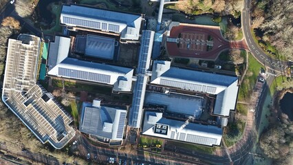 Aerial view of modern buildings with solar panels contrast with the surrounding bare trees and winding roads from above, Royal Leamington Spa, England, United Kingdom.