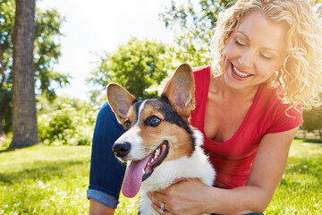 Smile, love and dog with woman in park for connection, bonding and animal adoption. Pet care, loyalty and happiness with person and welsh corgi outdoor for protection, relax and canine companion