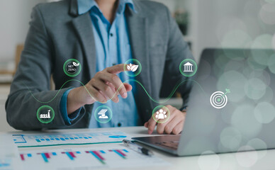 Business professionals are using digital interfaces that showcase ESG concepts, sustainability, energy, renewable energy, environment, sustainability analytics, and green investment.