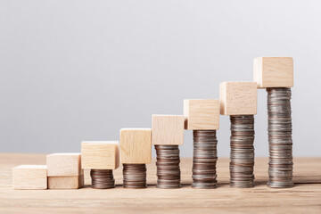 Wooden Blocks and Coins Forming Upward Steps for Income Growth