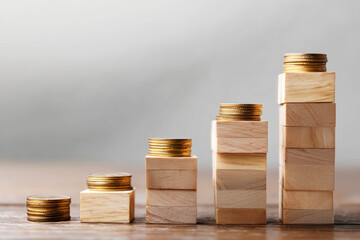 Wooden Blocks Forming Steps with Coins for Income Growth Concept