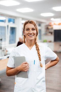 Nurse with tablet smiling in modern hospital rehabilitation setting