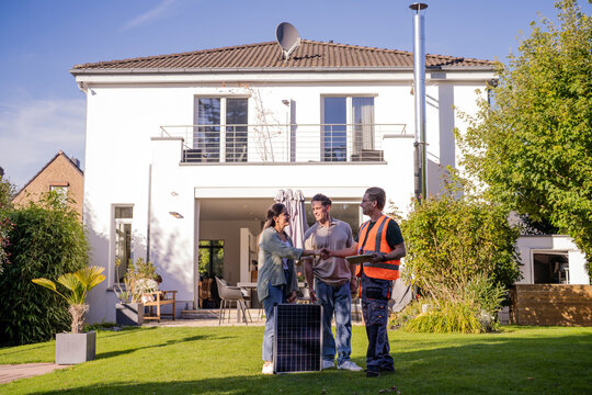 Family consulting with technician about solar energy at home