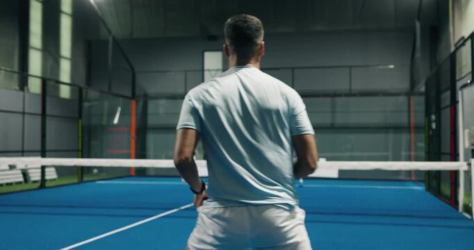 Athlete, people and padel games on court for fitness, match practice and swing technique. Back, men and hitting ball with racket for sports challenge, tennis competition and preparation of tournament