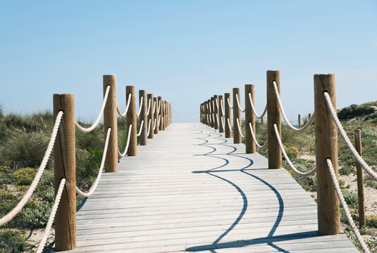 Wooden boardwalk along beach dunes in Majorca Spain on a sunny day