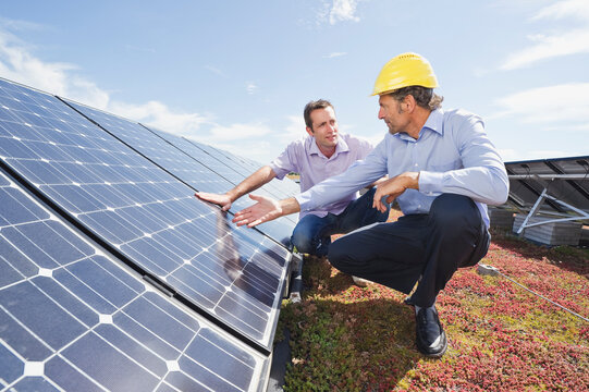 Engineer and supervisor inspecting solar panel installation outdoors