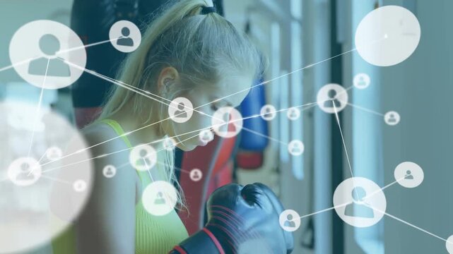 Animation of connected icons over caucasian woman wearing gloves punching boxing
