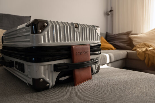 Closed  suitcase with passport, travel documents and luggage ready for departure