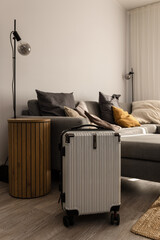 Hard-shell suitcase  in modern living room, travel luggage ready for departure