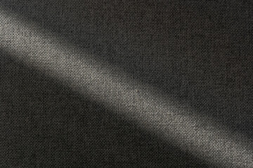 Neutral gray woven fabric texture with sunlight and shadows, abstract background for design